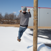 Man Doing Pull Up on Street Banner Pole